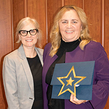 two women posing for an awards picture